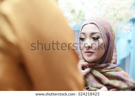 Young beautiful bride applying wedding make-up by make-up artist. malay wedding ceremony. islamic bride