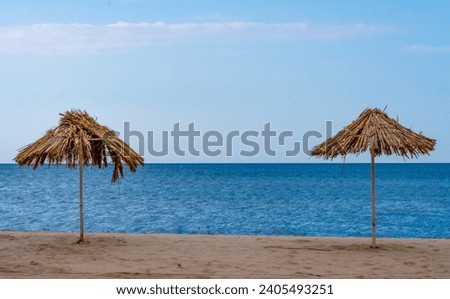 Similar – Image, Stock Photo two straw beach umbrellas on an empty seashore on a clear day