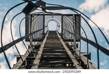 Foto Bild alte rostige Treppe mit Schäden gegen den blauen Himmel und die Wolken