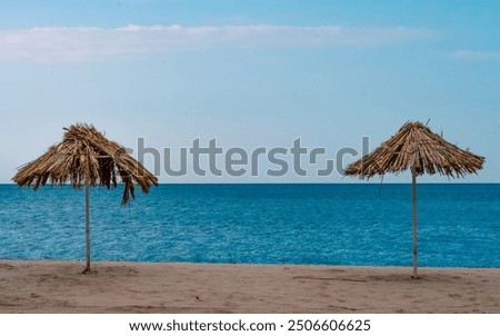 Image, Stock Photo two straw beach umbrellas on an empty seashore on a clear day