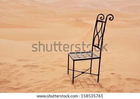 black steel chair setting lonely on the top of sand dune, Sahara desert, Morocco