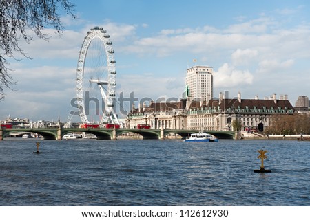 LONDON, ENGLAND - APRIL 30: London Eye and South Bank of Thames river in London, England taken on April 30, 2013. It is the tallest Ferris wheel in Europe and is a very popular tourist attraction,