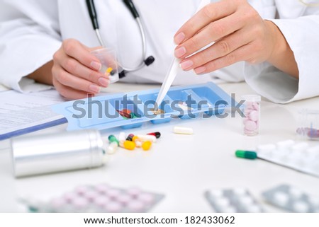 Healthcare worker assembles a daily tray of pills for a patient