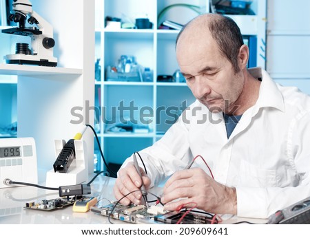 Senior male tech tests electronic equipment