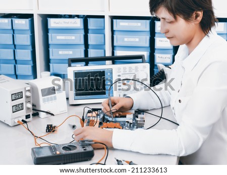 Tech tests electronic equipment in service center, toned image