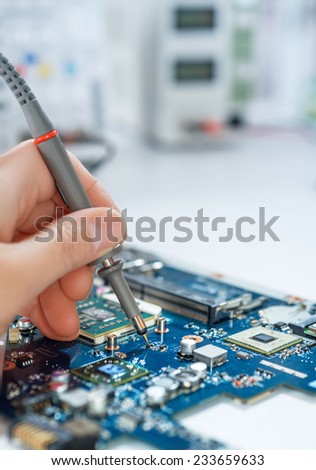 Electronics repair service, hand of female tech fixes an electronic circuit, text space