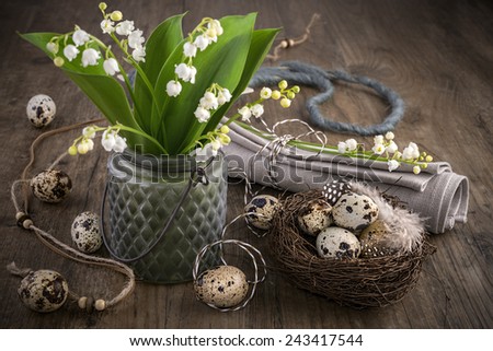 Lily of the valley and checkered Easter decorations on old wood, Happy Easter\