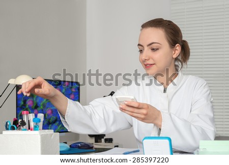 Young attractive female scientist or tech works in  research facility