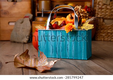 Autumn decorations on vintage kitchen in turquoise and orange hues. Shallow DOF, focus on the metal basket. This image is toned.