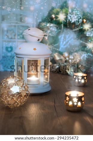 Decorative lantern, candles and Christmas decorations on vintage kitchen. Shallow DOF, focus on the lantern glass