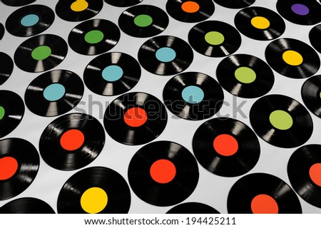 Music - Vinyl records. Colorful collection of vinyl records, LPs, on grey background, angle view. The labels can be easily customized, the image is suitable for background use.