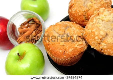 Apple Spice muffins on a white background with 2 green granny smith, one red apple and cinnamon sticks