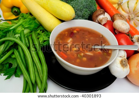 Hot vegetable soup with a sprig of basil served in a white bow