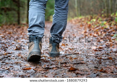 Close up of hiker walking down the wet forest path. Person with dirty hiking shoes on the footpath outdoors. Photo stock © 