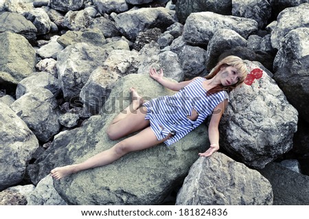 Girl with a broken and a broken head is on the rocks