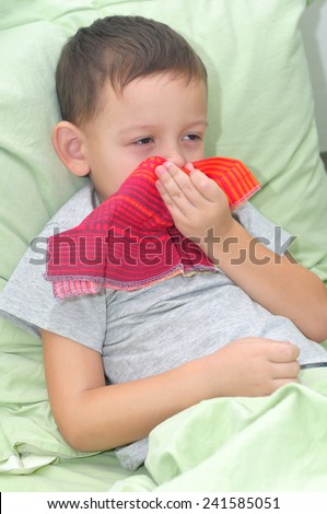 The boy is sick. Lies in pastels and blowing his nose