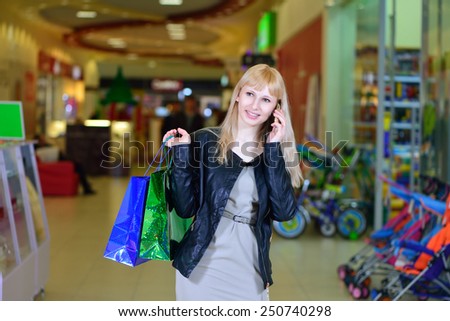 Girl with purchases in the store talking on the phone