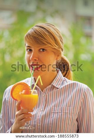 Girl with orange juice and straws in the glass