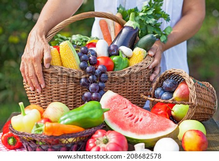 Summer fruit and vegetables with a woman holding the basket