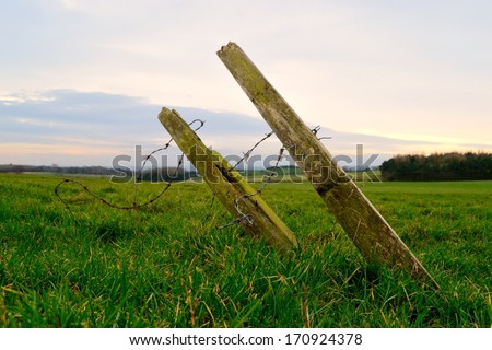 Old wooden fence post in rural field near Rightington, England.