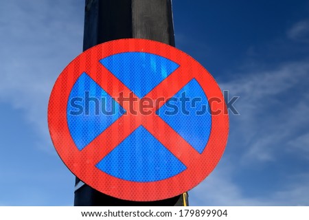 The urban clearway sign with blue skies in the background.