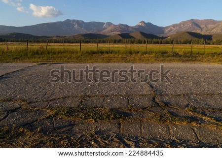 The old cracked road with beautiful valley and mountains in background.