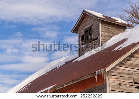 The rustic wooden barn roof with snow.