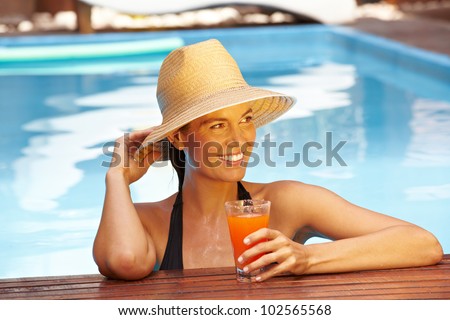 Happy smiling woman with straw hat in swimming pool