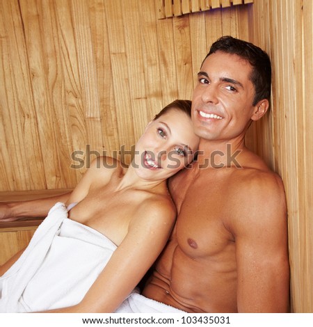 Attractive happy couple relaxing together in a sauna