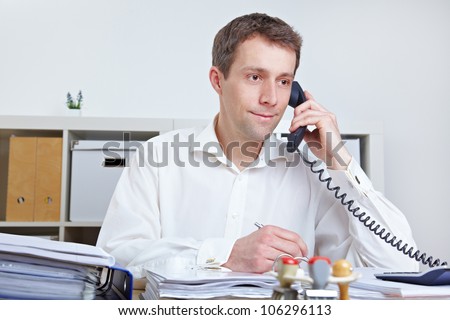 Business man making a call at his desk in the office
