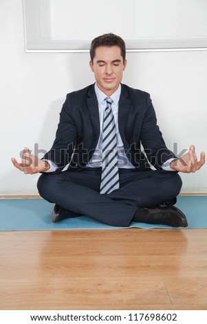 Relaxed business manager doing yoga in his office