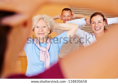 Fitness trainer giving senior fitness class in a health club