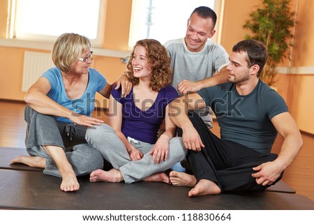 Smiling group with men and women talking in a fitness center