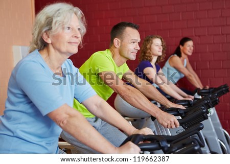 Group riding spinning bikes in a fitness class in health club