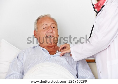 Senior man in hospital bed getting auscultating with stethoscope from a nurse