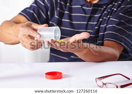 Elderly senior hands taking different pills and medicine