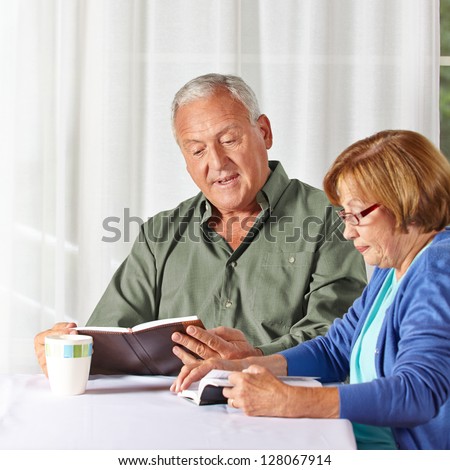 Senior couple reading books together in a rest home