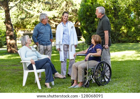Geriatric nurse with senior group in garden of a retirement home