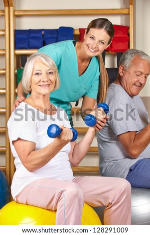 Happy senior man and woman in gym doing fitness in a nursing home