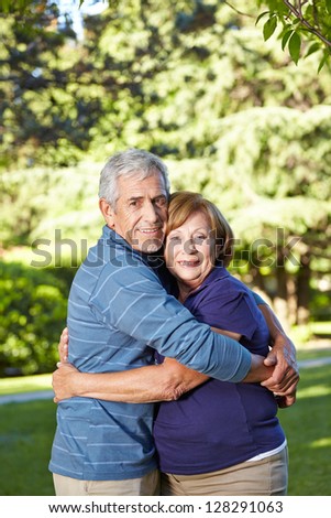 Two happy seniors in love embracing in a summer park