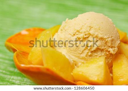 Scoop of homemade mango ice cream with fresh mangos