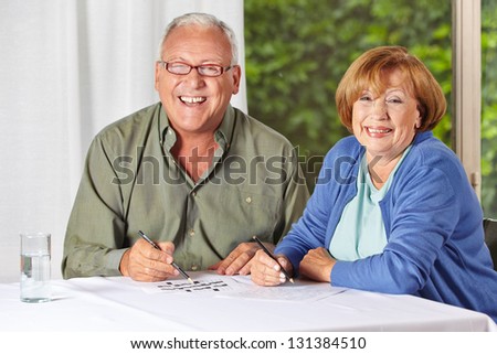 Two happy senior people solving riddles in a retirement home