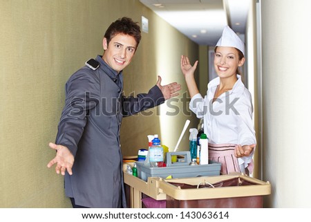 Concierge and hotel maid with cleaning cart in corridor