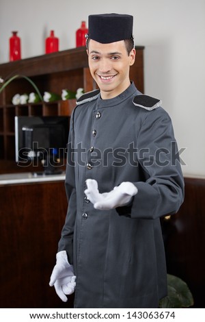 Happy concierge greeting guests in hotel on welcome