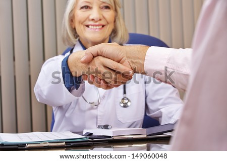 Smiling doctor and patient giving handshake after a consultation