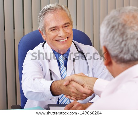Doctor giving welcome handshake to patient in his office