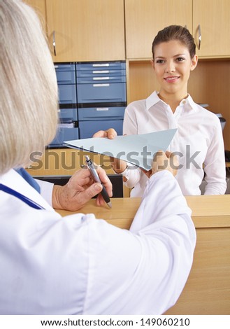 Doctor getting medical records in hospital from the receptionist