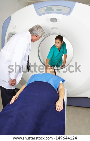 Doctor and nurse with patient at MRI machine in radiology in a hospital