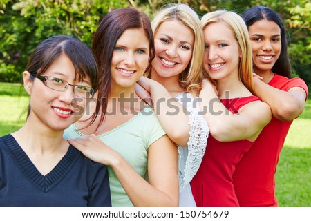 Team of five happy young women smiling in nature