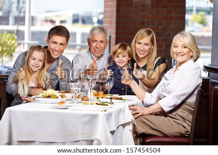Happy family congratulate in restaurant holding their thumbs up